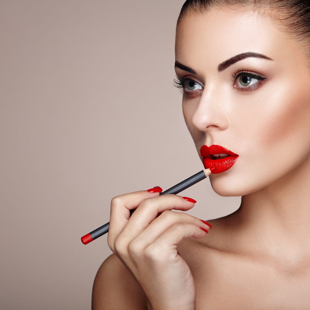 beautiful woman paints lips with lipstick 2023 11 27 05 26 12 utc